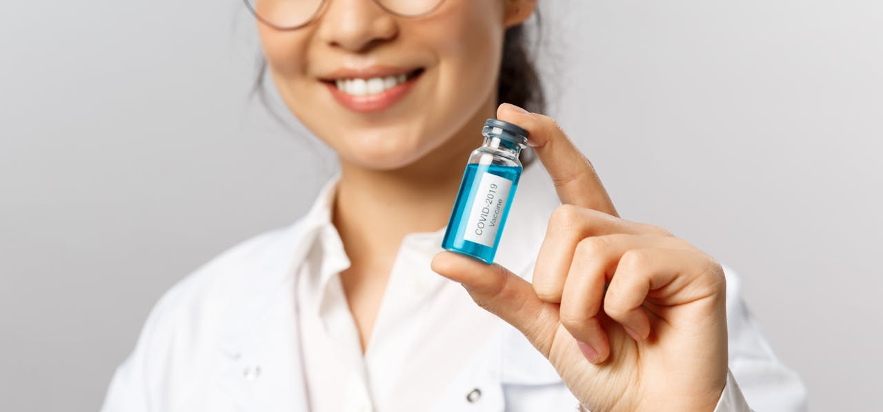 Close-Up Shot of a Woman Holding a Covid-19 Vaccine